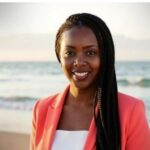 an attractive black female entrepreneur with a beautiful beach in the background.